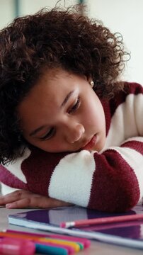 Girl, bored and sad with book for homework for project, thinking and exhausted in morning. Child with learning disability, annoyed or frustrated with notes, assignment and tired with worry at house