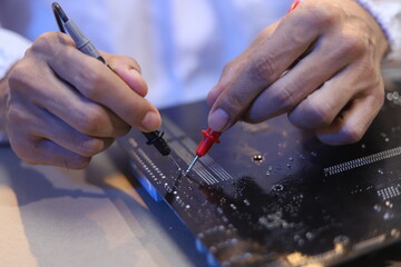 Obraz premium technician wearing white gloves fix circuit board using a magnifying glass tool during professional electronic hardware repair on a fully equipped modern technology workstation desk.