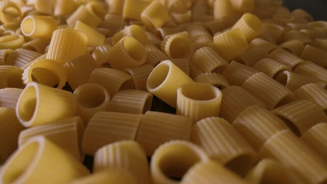 50p POV macro slider shot across uncooked mezze maniche pasta.