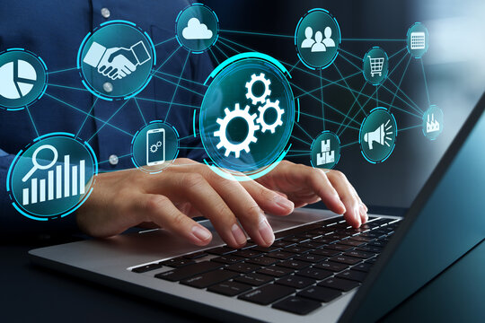 Business process automation technology. System integration and process optimization. Businessman using laptop computer to work with automated workflow software. Network structure and gear icons.