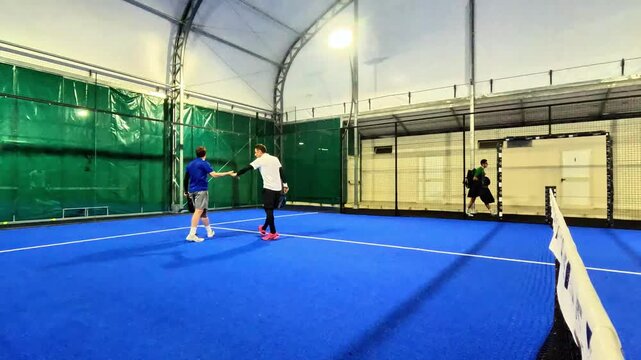 Game action during a padel match between amateurs. Two players win the point and congratulate each other