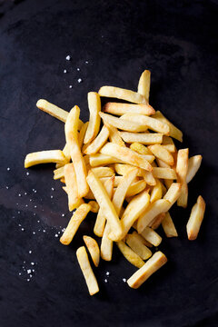 French fries and salt on dark ground