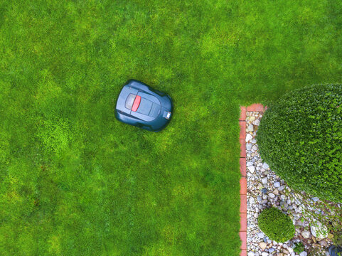 Germany, Bavaria, robotic lawn mower on meadow
