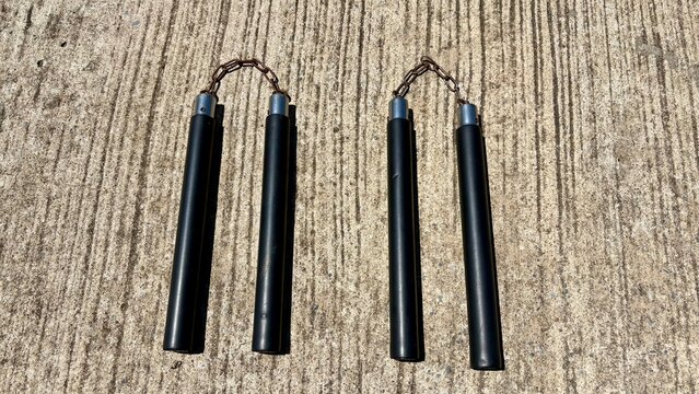 Double black nunchaku is on the street , hard light , isolate image.