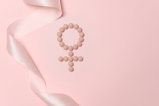 Female gender symbol with pink ribbon on pastel background for women wellness awareness