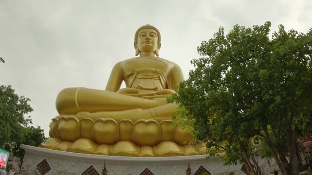 video footage highlights the magnificent golden Buddha statue at Wat Paknam Phasi Charoen in Bangkok. The colossal, serene statue is captured sitting in a meditative pose on a lotus base.