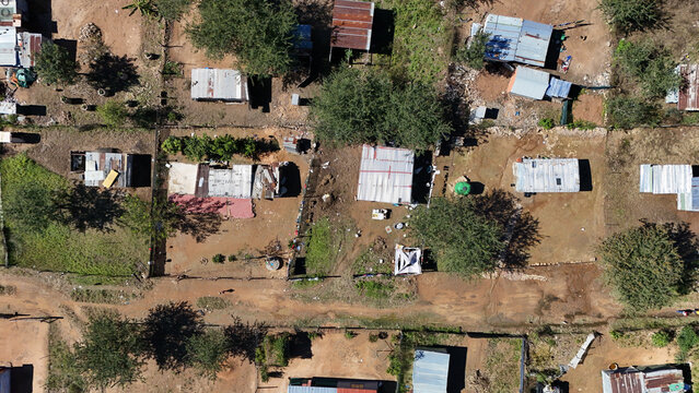 Aerial view of a rural settlement featuring corrugated iron roofs and dirt paths among sparse trees in Vaalwater, Limpopo, South Africa.