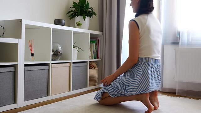 Young woman using storage box from shelving system in home interior. Home organization and decluttering routine concept