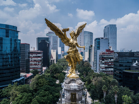 Aerial view of The Angel of Independence monument surrounded by modern skyscrapers and lush green trees in Ciudad de Mexico, Ciudad de Mexico, Mexico.