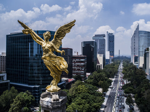 Aerial view of The Angel of Independence statue overlooking Paseo de la Reforma with modern skyscrapers and traffic in Ciudad de Mexico, Ciudad de Mexico, Mexico.