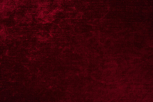 Dark red crushed velvet texture background, luxury burgundy velour fabric with soft shiny pattern.