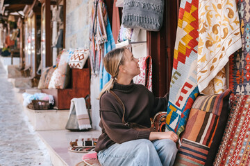 Female traveler shopping at local vintage market in historic street, authentic travel, secondhand fashion, artisan goods and sustainable lifestyle concept. © shintartanya