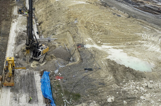 Aerial view of a large piling rig and heavy machinery operating on a construction site with workers and excavated earth Beylikduzu, Istanbul, Turkiye.