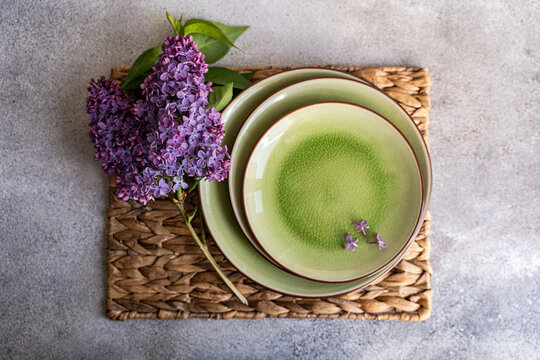 Overhead view of a rustic Spring place setting on a table with purple lilac flowers