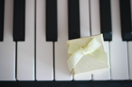 Close-up overhead view of a gift box tied with a ribbon on piano keys