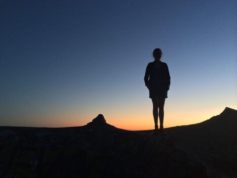 Silhouette of a woman in shorts standing on top of Grizzly Peak at Sunset, Berkeley Hills, Berkeley, California, USA