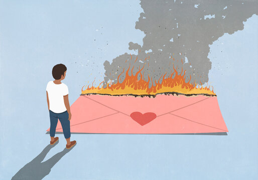 Man looking down at large burning large pink envelope with red heart shape sticker