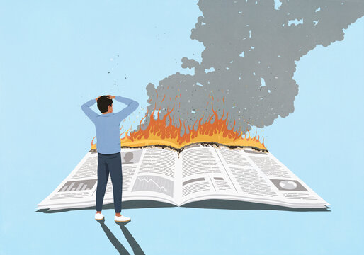 Shocked man with hands on head watching newspaper on fire