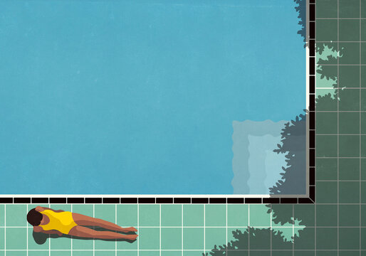View from above of woman in bathing suit relaxing in sunlight, sunbathing next to blue swimming pool