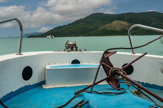 View of the sea and the island from the bow of a pleasure boat with an anchor