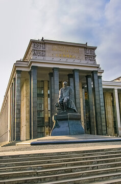 Moscow, Russia - November 8, 2007: The bronze seated statue of Russian writer Fyodor Dostoevsky stands in front of the colonnaded facade of the Russian State Library, formerly known as the Lenin State
