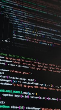 Close-up view of a computer monitor displaying React programming code with syntax highlighting in a dark mode interface. Concept of software engineering, AI integration, and web development.