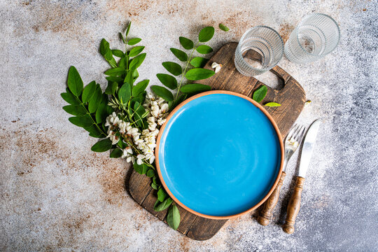 Overhead view of a rustic Place setting on a wooden chopping board with fresh Acacia flowers