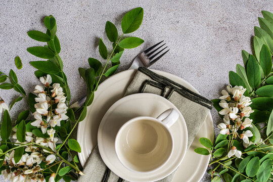 Overhead view of a place setting with fresh Acacia flowers on a concrete table