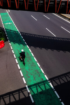 Overhead view of a cyclist riding his bike along an empty city road, Indonesia