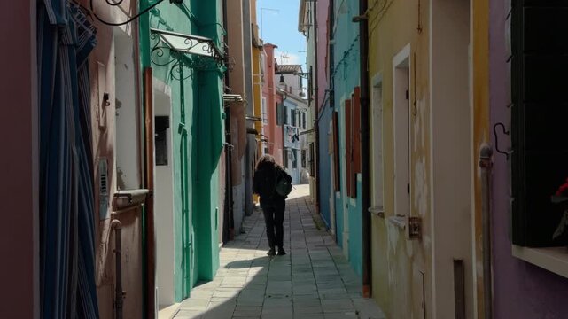 Solitary Traveler Walking Through a Colorful Burano Alley
