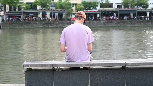 Man Sketching and Drawing on Notebook at Clarke Quay Riverside, Singapore