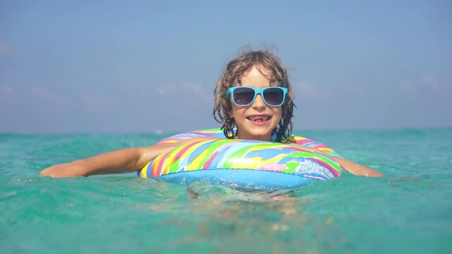 A happy child is having fun in the sea during the summer holidays. Slow motion