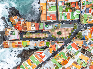 Aerial view photo from above wild waves in the Atlantic Ocean with colorful houses on Tenerife island in Puerto de la Cruz, Spain © Markus Mainka