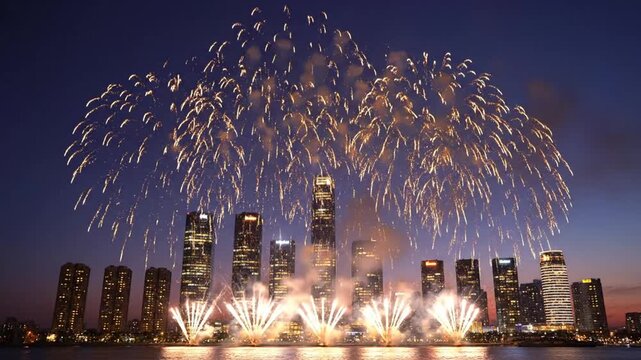 Bright fireworks explode over a modern city skyline at night