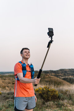 Male athlete vlogging outdoor while trail running