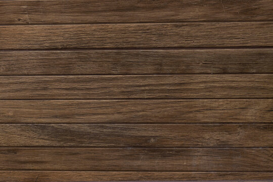 Dark brown wooden planks background texture with horizontal lines, old natural timber surface for design or wallpaper. Detailed warm dark brown tones of a felled tree trunk. Close-up wood texture.