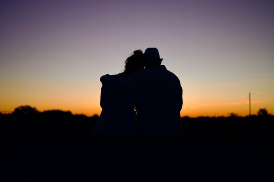 Romantic Couple Sitting Together on Cobblestone Path at Sunset