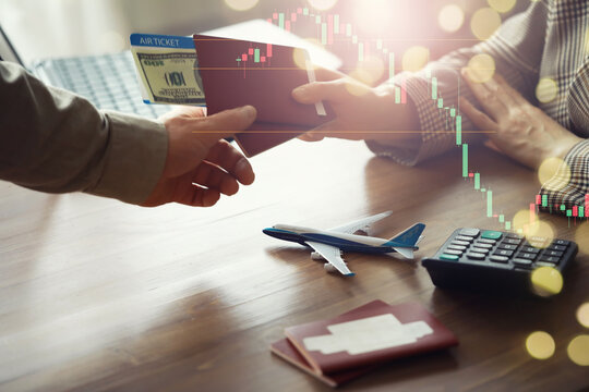 A man buys plane tickets from an agency. The client receives a passport with plane tickets from the travel agent.
