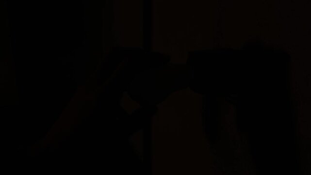 A person hand carefully screws a brightly glowing LED light bulb into an old electrical socket on a raw concrete wall. Concept of energy efficiency, home improvement, and bright ideas.