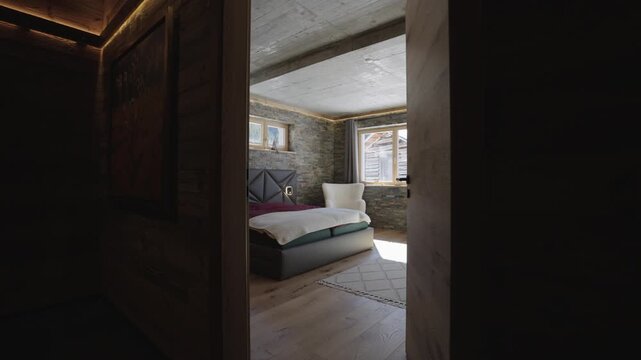 Camera entering a rustic luxury bedroom with stone walls and a scenic mountain view from the window