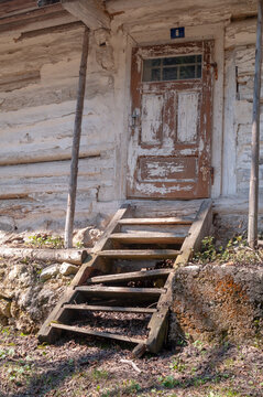 View of the weathered wooden door and rickety stairs of a traditional log cabin at the Prasnica - old charcoal burners' settlement Stare Hory, Banskobystricky kraj, Slovakia.