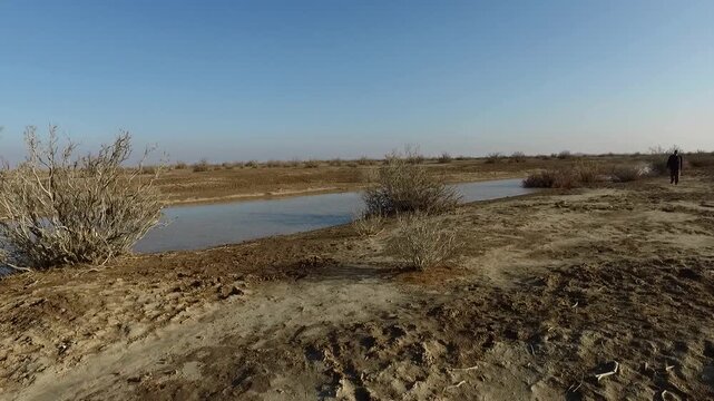 Wide river flowing through dry landscape with green patches in Iran creating water and nature documentary scene perfect for travel stock video footage.