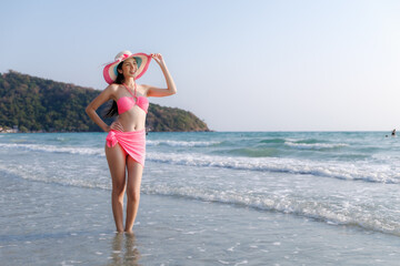 Naklejka premium Young Woman In Pink Bikini And Sun Hat Posing In The Clear Tropical Waters Of Rayong Thailand