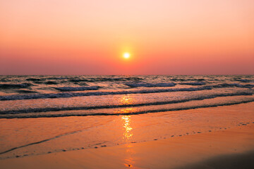 Fototapeta premium Golden Sunset Over Calm Ocean Waves On A Peaceful Tropical Beach In Rayong Thailand