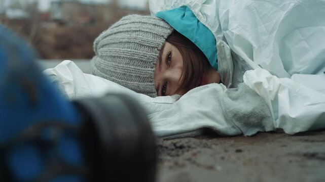 Caucasian scientist collapsed on icy street, wearing protective suit and gray beanie, respirator lying in foreground, abandoned urban wasteland with frost and rubble, researcher appears exhausted