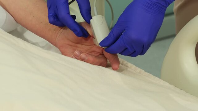 Nurse places pulse oximeter on woman finger in hospital bed. Medical worker fixes sensor clip checking fingertip position for reading