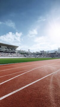 Athletics track lanes curving toward stadium under bright sky