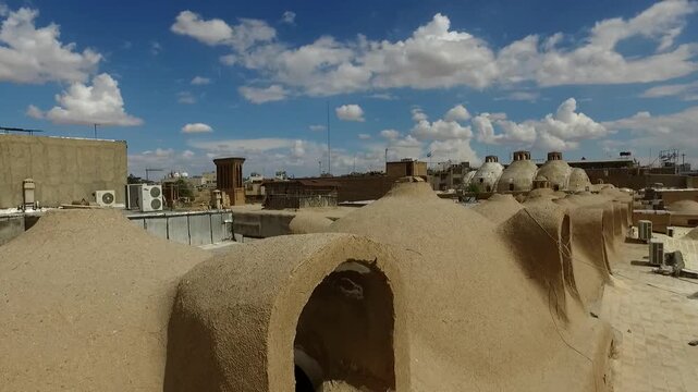 Mud brick buildings with arched doorways in desert village creating traditional architecture and cultural documentary footage perfect for stock video.