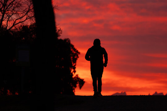 Silueta de hombre haciendo ejercicio al atardecer 