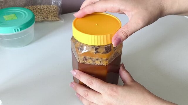 Woman opening a jar of natural honey sweet honey